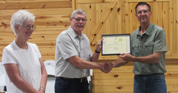 David Meyer (c), accompanied by Marianne Meyer (l), accepts the Honor Award from Doug Garrison, Nebraska SWCS awards committee member.